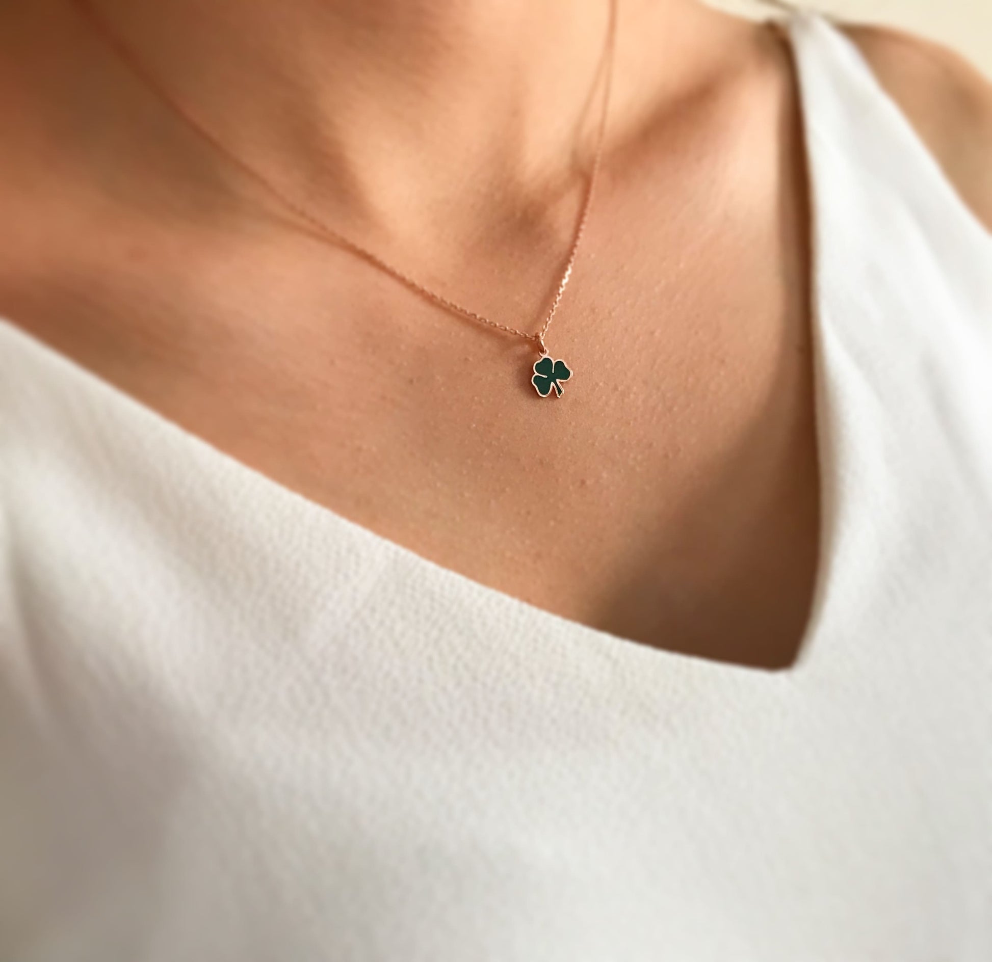 Gold necklace with green lucky charm